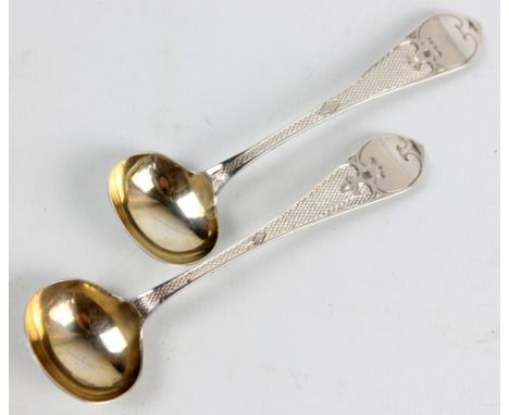 GEORGE UNITE; a pair of Victorian hallmarked silver mustard spoons with engine turned decorated stems and Celtic point finial