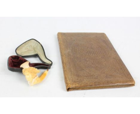A meerschaum pipe in the form of a woman's head wearing a bonnet, length 6cm and an 1849 copy of 'Song of Songs' illuminated 