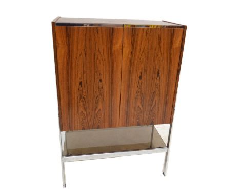 RICHARD YOUNG FOR MERROW ASSOCIATES; a rosewood and chrome cocktail cabinet with twin hinged doors enclosing two glass shelve