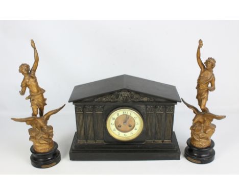 An early 20th century slate mantel clock with three applied pediments to either side of the dial and applied mask decoration 