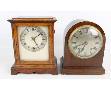 An Edwardian mahogany dome top mantel clock, the silvered dial set with Roman numerals and an early 20th century oak mantel c