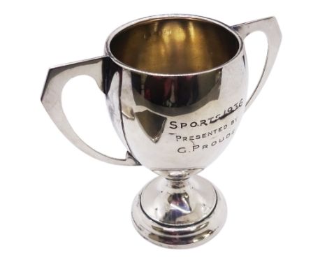 1930's silver trophy cup, of typical form, with twin angular and curved handles, the bowl with presentation engraving, upon a