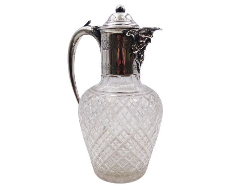 Edwardian silver mounted claret jug, the ovoid clear cut glass body with silver mounted collar with Bacchus mask spout, domed