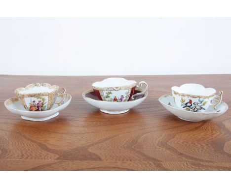 A GROUP OF THREE DRESDEN QUATREFOIL CUP AND SAUCERS18th/19th century, one of the cups with a burgundy ground and figural scen