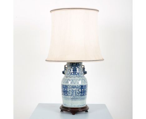 A CHINESE BLUE AND WHITE CERAMIC LAMP with applied lion dogs to the sides, of floral and geometric decoration, surmounted on 