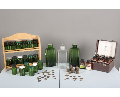 A PAIR OF 1950S GREEN GLASS ‘EASY STACK’ PHARMACY BOTTLES&nbsp;with stoppers, 22.5cm high; together with a similar clear glas