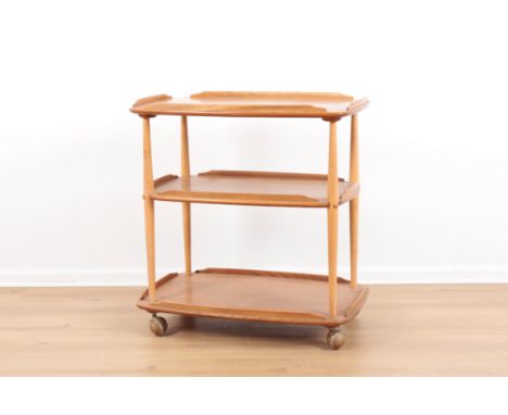ERCOL, MODEL NO. 458: A BEECH AND ELM THREE TIER TROLLEYmid-century modern, each tier part-galleried, terminating on turned l