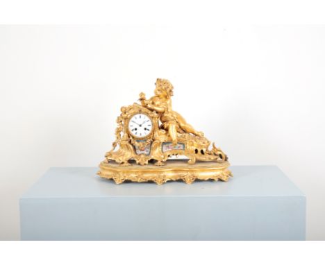 BERGER OF PARIS: A FRENCH GILT METAL MANTEL CLOCK 19th century, the white enamel dial surmounted by scrolling gilt metal with