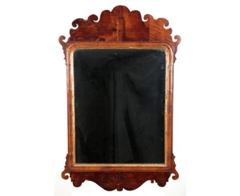 AN ENGLISH MAHOGANY MIRROR18th century, the rectangular plate within a gilt inner slip and a shaped frieze with conforming ap