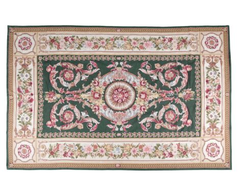 A NEEDLEPOINT CARPET OF SAVONERRIE DESIGN woven in colours with circular medallion and rose garlands, on a green ground withi