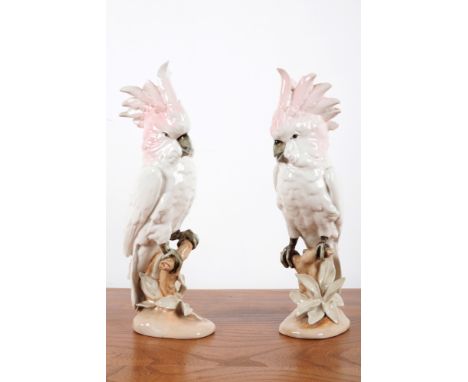 A PAIR OF ROYAL DUX COCKATOOS 20th century, each decorated with a pastel pink crown and white body, perched upon a naturalist