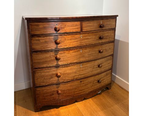A VICTORIAN MAHOGANY SERPENTINE CHEST OF DRAWERStwo small drawers above four long with turned knobs, with shaped apron and te