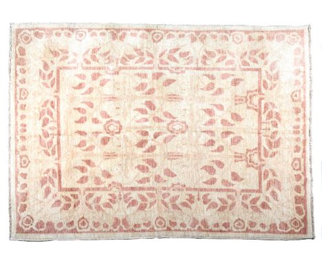 AN ARTS &amp; CRAFTS CARPET woven in ochre with subtle all-over leaf design on a tan ground, 243cm x 189cm