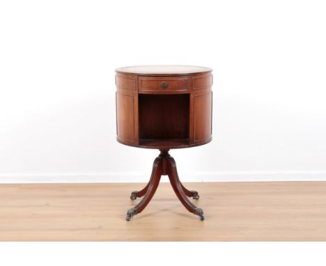 A REGENCY STYLE MAHOGANY DRUM REVOLVING BOOK TABLEwith tooled leather top, three drawers and three dummy drawers, terminating