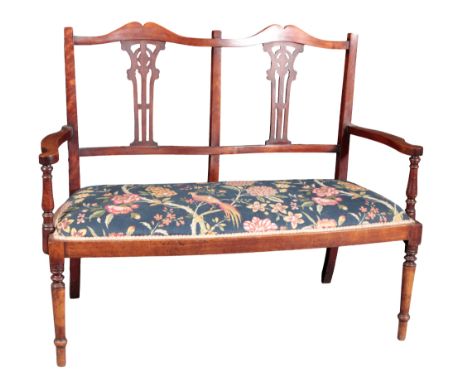 AN EDWARDIAN MAHOGANY SETTEE the shaped cresting rail over pierced lyre shape back splats and a stuffed bowfront seat, on tur