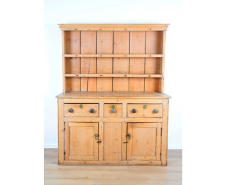 A PINE DRESSER19th century, the upper part with a moulded cornice and two fitted shelves, the base fitted with three drawers 