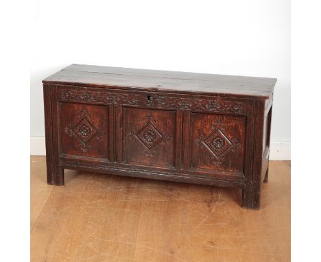 A PANELLED OAK COFFERlate 17th century, with three plank top, a fretwork panel below with triple lozenge front with stylised 