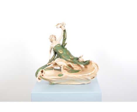 EDUARD STELLMACHER (GERMAN 1868-1929) FOR AMPHORA POTTERY CO.: AN ART NOUVEAU OR JUNGENSTIL NYMPH FIGURAL CENTREPIECE holding