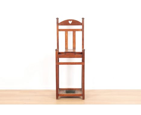 AN ARTS AND CRAFTS OAK HALL STANDcirca 1900, the arched top rail with a pierced heart motif, a glove box with hinged lid, and