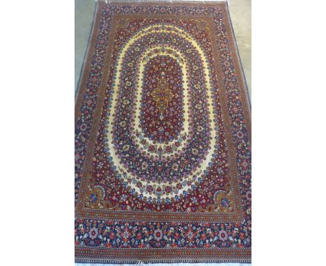 A fine silk inlaid Kashan, hand knotted with approximately 400-500 knots per square inch, with red, blue and caucasian fields