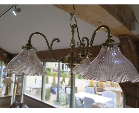 An Edwardian brass three branch centre light with holophane shades - 58cm wide - in clean condition 