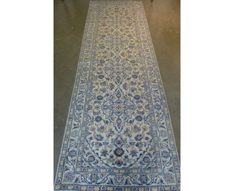 A Kashan runner, hand knotted, woollen rug with caucasian ground, approximately 298cm x 97cm, some light wear otherwise in go