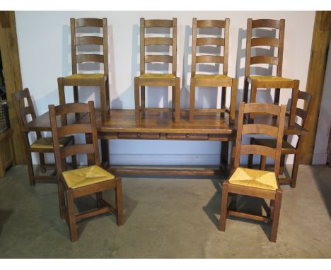 A Wesley Barrell French oak refectory table with two extension side leaves, and eight ladder back chairs, table 76cm H x 85cm