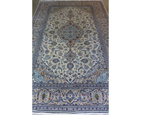 A Kashan, hand knotted, woollen rug, with caucasian ground, approximately 300cm x 200cm with some light wear 