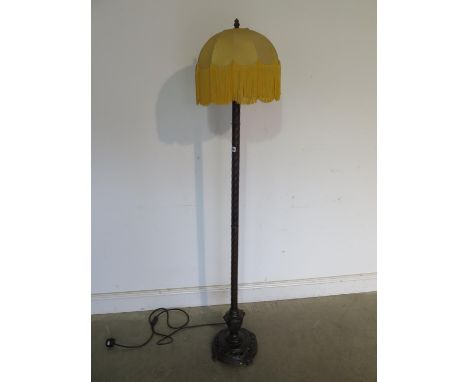 A very unusual 1920s standard lamp and shade, bronzed metal column finishing in a cast iron base mounted on four small feet, 