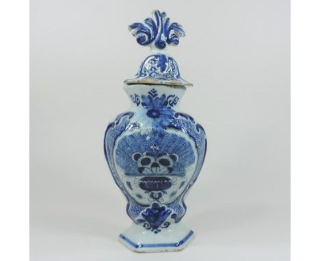 An 18th century Dutch Delft blue and white vase and cover, the lid with scrolled finial, the body depicting a basket of flowe