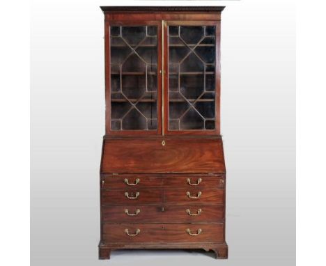 A George III mahogany bureau bookcase, the dentil moulded cornice above two astragal glazed doors, the fall enclosing and arr
