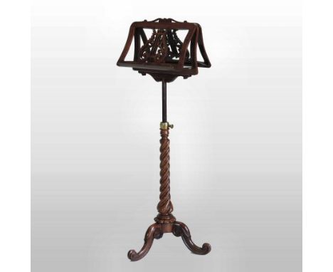 A Regency carved rosewood duet music stand, the ratcheted adjustable top with fret carved lyre decoration, on a spirally turn