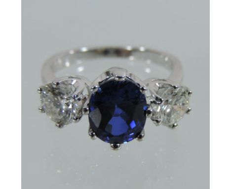 An impressive 18 carat white gold three stone sapphire and diamond ring, the central sapphire approximately 2.0 carat, flanke