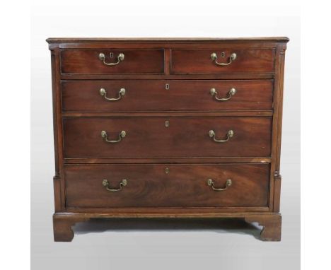 A George III mahogany chest, containing two short over three long graduated drawers, flanked by fluted columns, on bracket fe