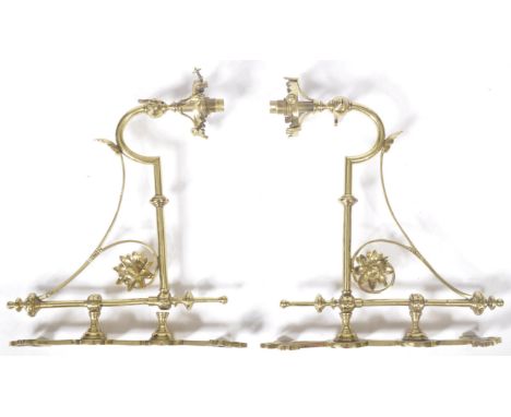 A matching pair of 19th Century Gothic Revival brass worked wall light sconces of decorative scrolled form mounted upon eccle