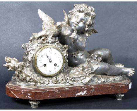 A 19th Century French spelter figural mantel clock. The clock of large size and depicts a cherub winged putti playing with do