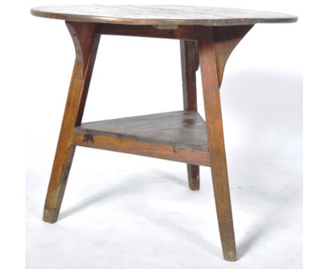 An 18th Century George II oak cricket table / side occasional table having an oval / elongated circular top raised on triform