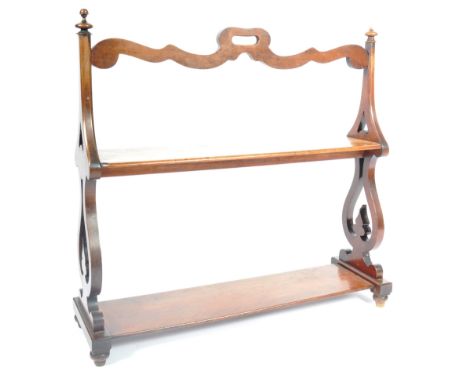 A 19th Century Victorian two tier mahogany double sided open bookcase having carved open sides with turned finial tops with a