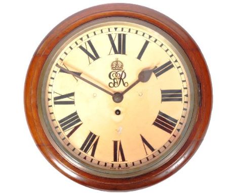 A 20th Century George V 1932 mahogany cased station wall clock having a white enamel face with Roman numeral chapter ring. Fa
