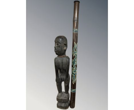 An African hardwood carving of a man, height 87 cm, together with an Australian didgeridoo.
