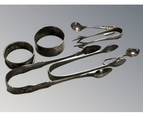 A pair of Georgian Newcastle silver sugar tongs, further smaller pair, plated pair of tongs, two silver caddy spoons and two 