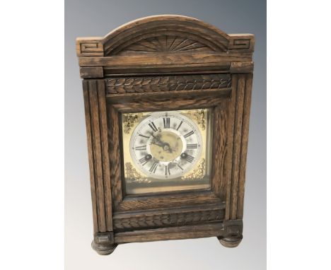 An early 20th century oak eight day bracket clock with brass and silvered dial, height 36 cm, with pendulum