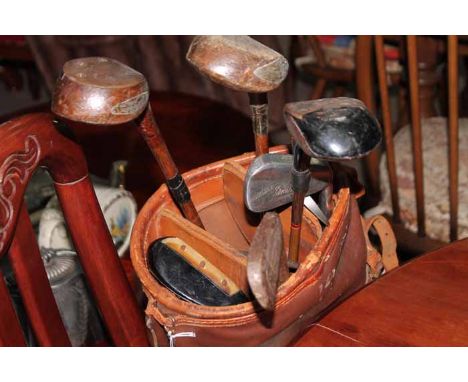COLLECTION OF GOLF CLUBS IN LEATHER CADDY BAGTo include a hickory shaft putter in the style of a Philp putter along with 8 ot