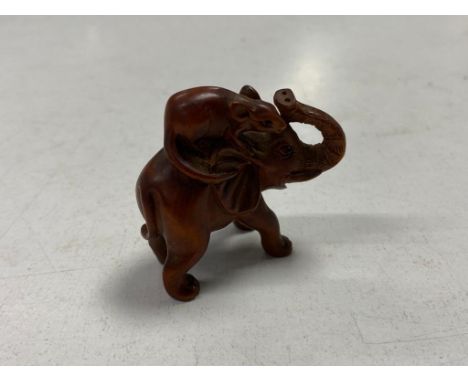 A Japanese carved wooden netsuke in the form of a rat riding on the back of an elephant 