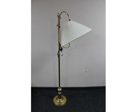 An adjustable brass floor lamp with shade 