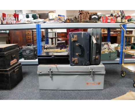An early twentieth century tin trunk together with two mid century luggage cases and a metal deed box 