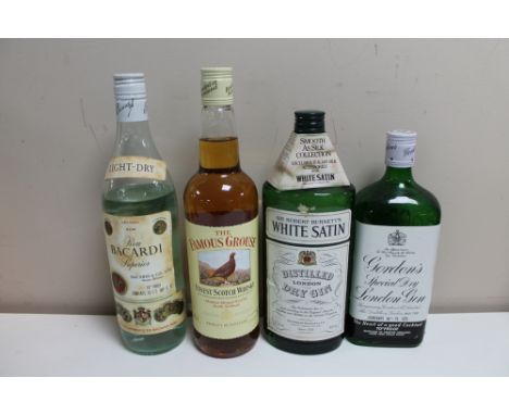 Four bottles of alcohol - Gordons Special dry London gin, White Satin London gin, Bacardi and Famous Grouse Scotch 