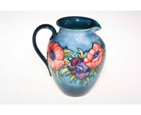 Moorcroft jug decorated with anemone design on a light blue background, 22cm high.