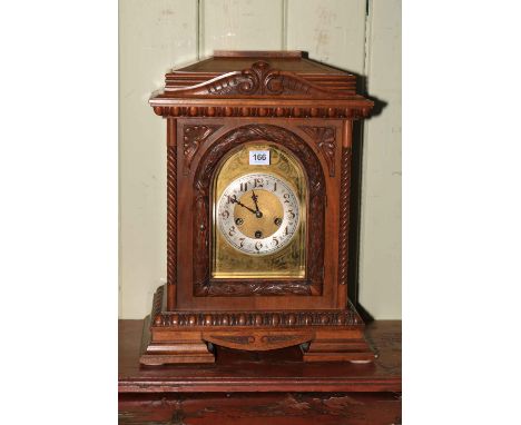 A large mahogany mantel clock on bracket feet, having arched dial, 48cm high.