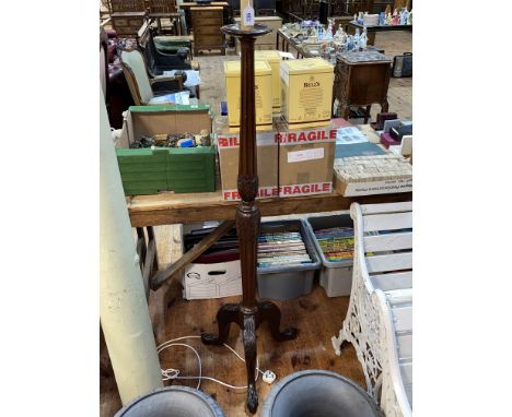 Carved mahogany triform standard lamp on claw feet.